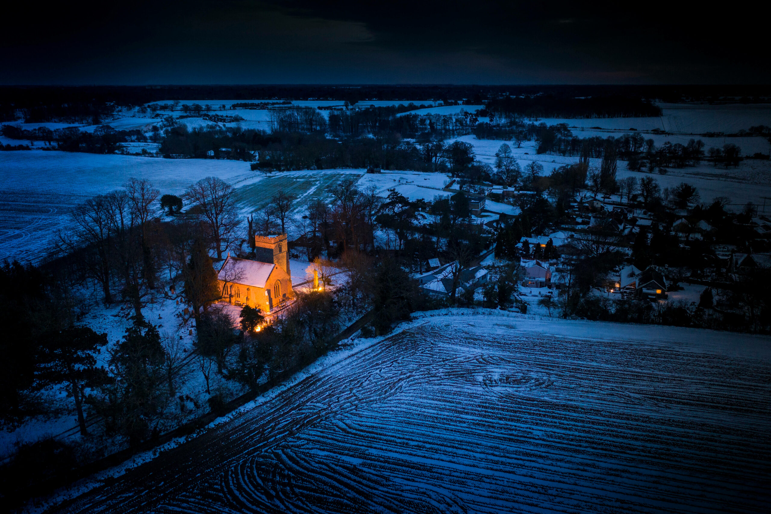 Playford Church illuminated in the winter night